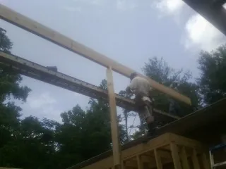 Carpenter setting a ridge beam over a new addition frame — Ice Dam Removal by Roofing Brothers in Dolomite
