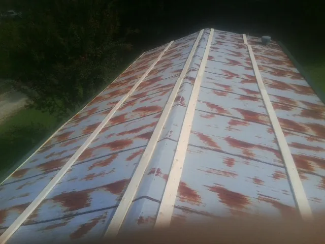 Rusted metal roof panels with new wood purlins before replacement — Storm Damage Roof Repair in Dolomite by Roofing Brothers