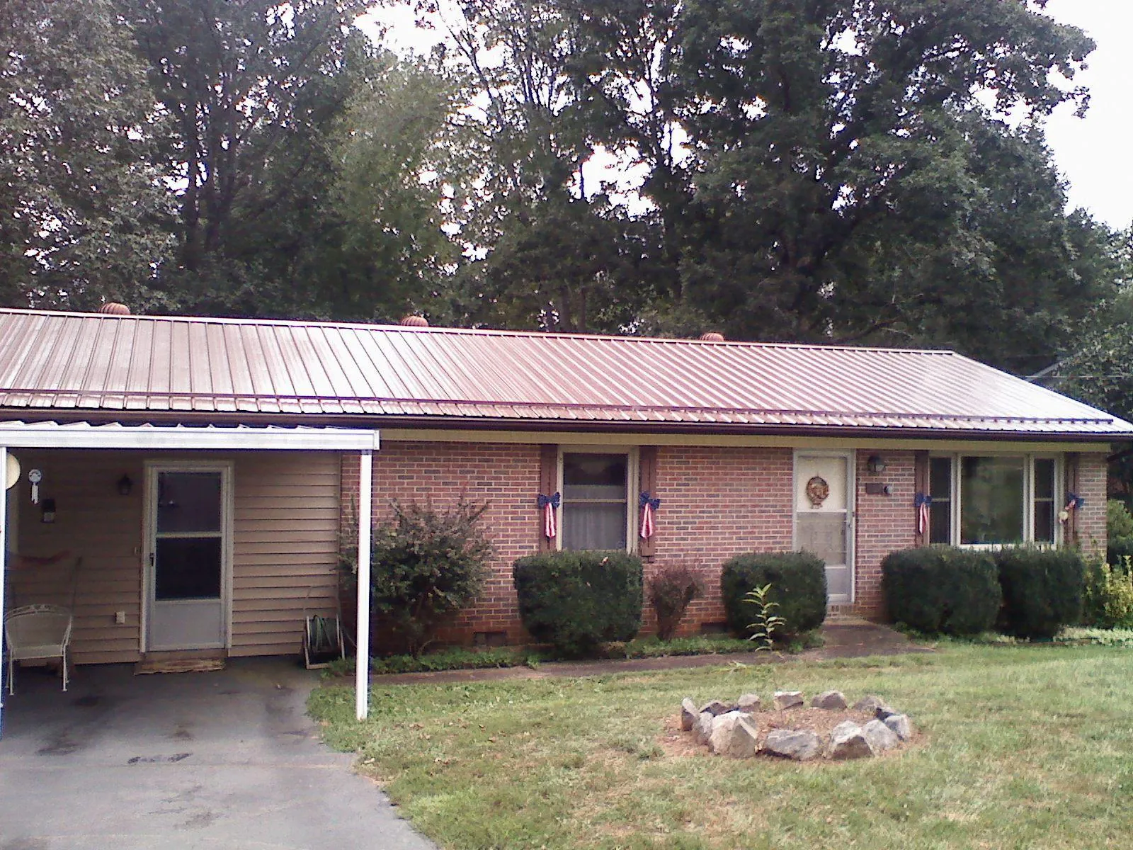 Bronze metal roof and carport on a brick ranch home — Roof Repair work by our crew in Dolomite